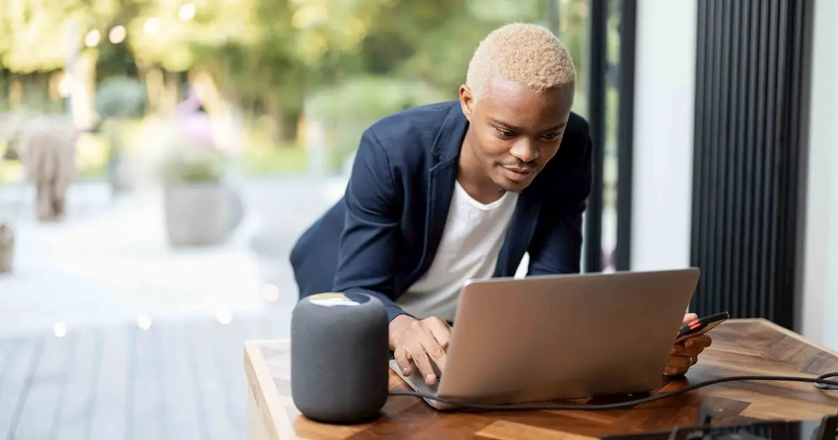 Person with blonde hair using a laptop outdoors.