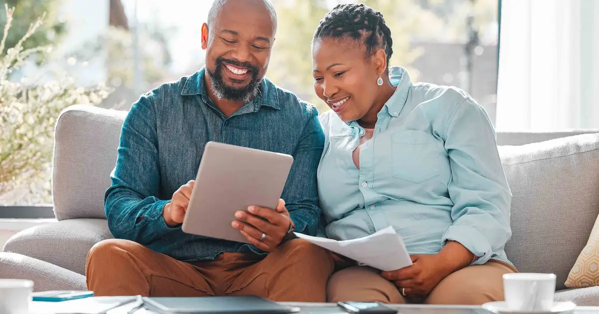 Smiling couple reviewing financial documents.