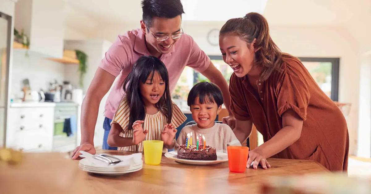 Family celebrating child’s birthday with cake.