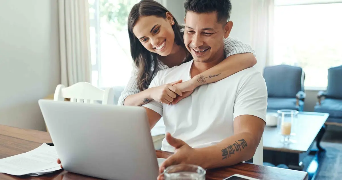 Happy couple looking at laptop.