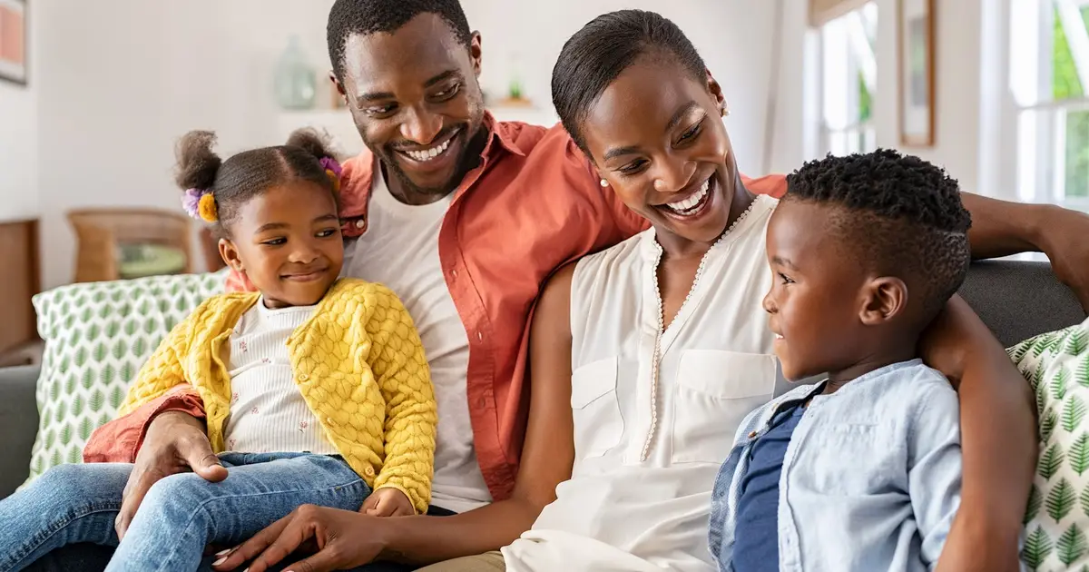 Family of four sitting on a couch.