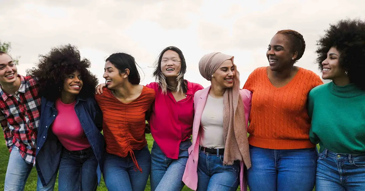 Diverse group of women embracing, symbolizing unity.