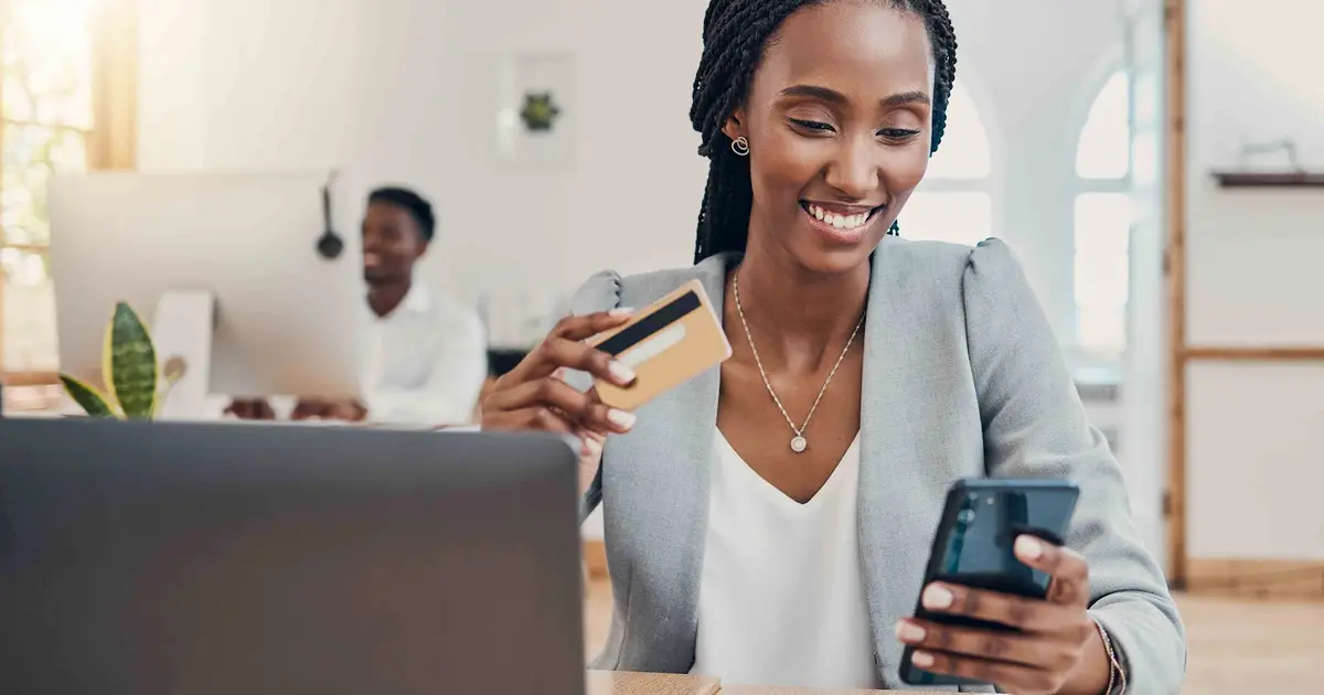 Woman using smartphone and credit card.