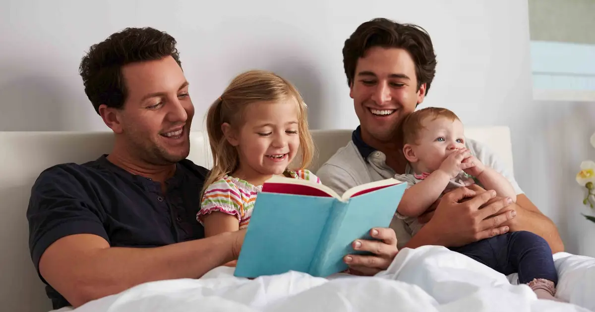 A family of four reading together, sharing a warm bonding moment.