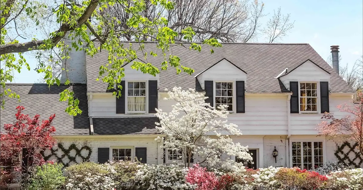 White house surrounded by spring flowers.