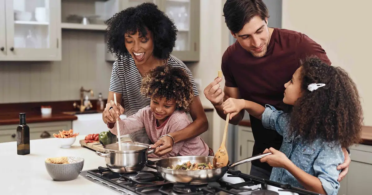 Smiling family of four cooking together.