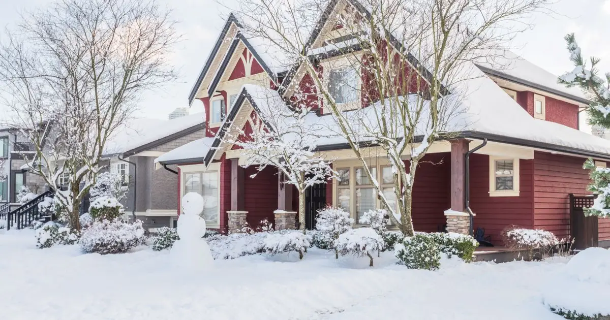 A red house and a snowy landscape.
