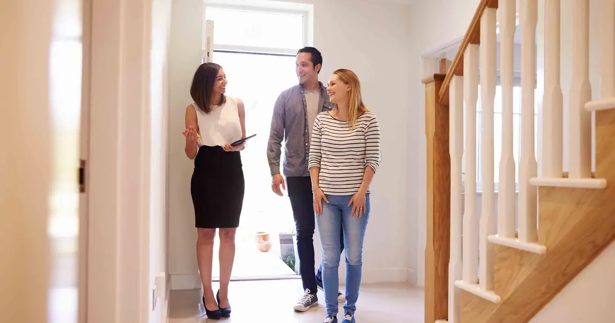 Real estate agent and smiling couple.