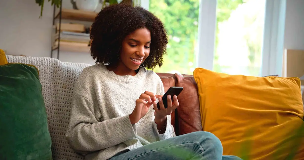 Woman using phone on couch.