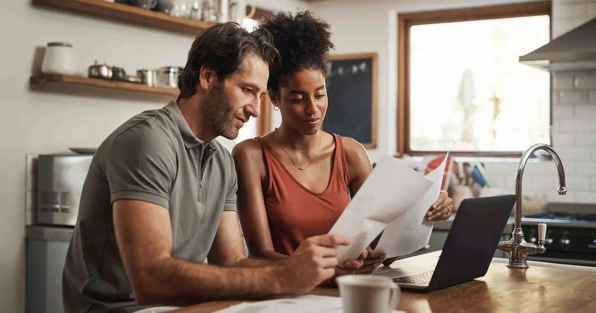 Couple reviewing documents in kitchen.