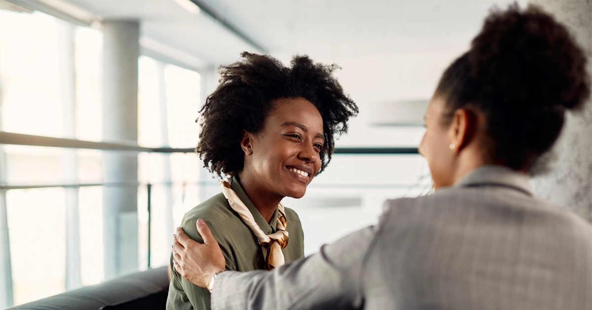 Two women talking in an office.