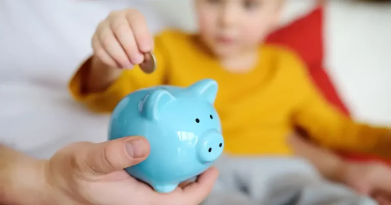 Young child putting money into piggy bank