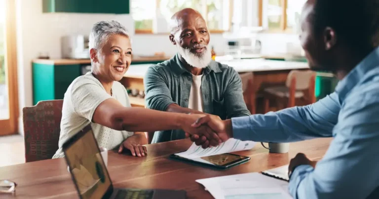 Retired couple shaking hands with loan officer