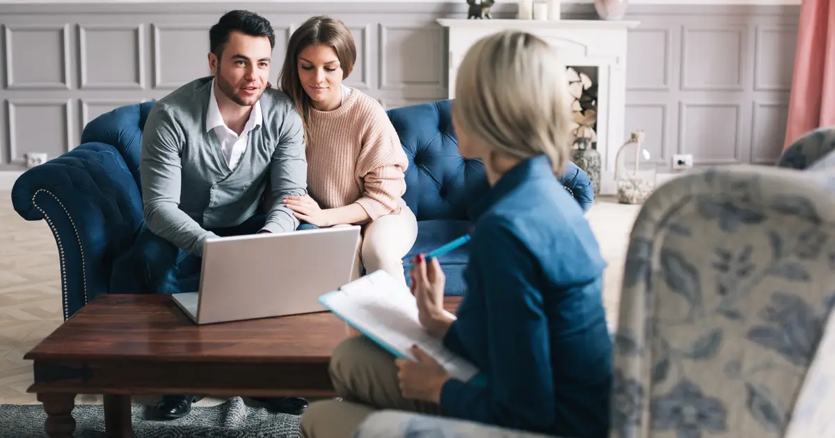Smiling couple talking with agent